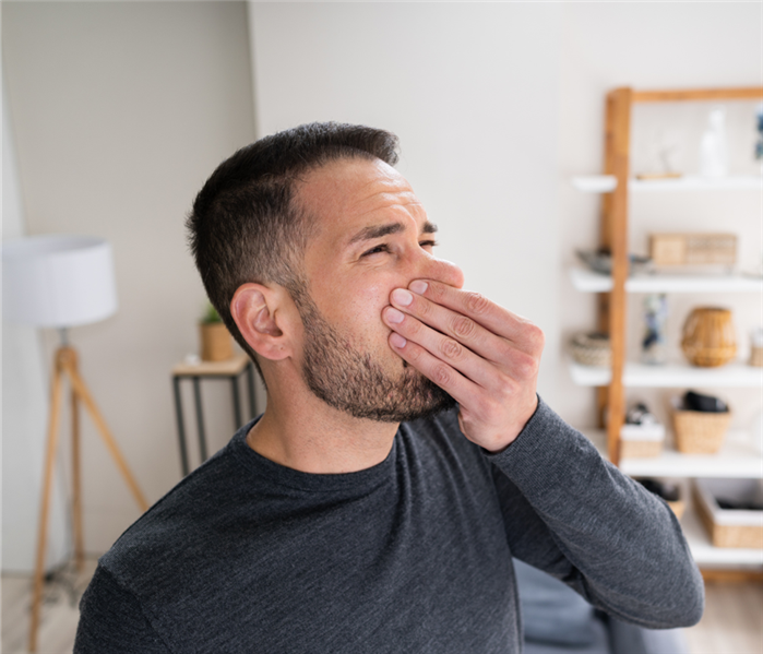 man plugging his nose in a home