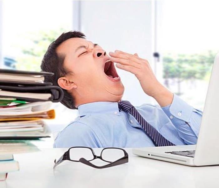 Man yawning at desk