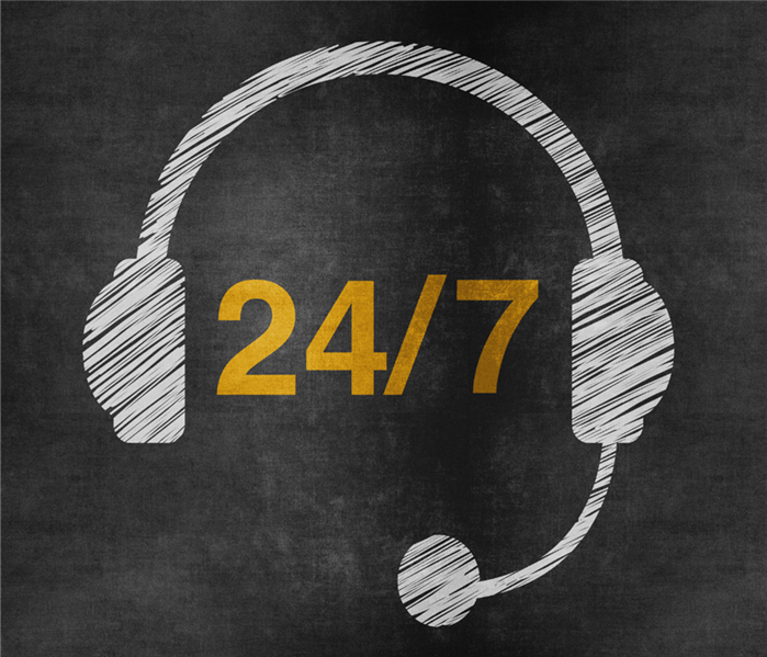 A headset drawn from chalk sits around the numbers 24/7.